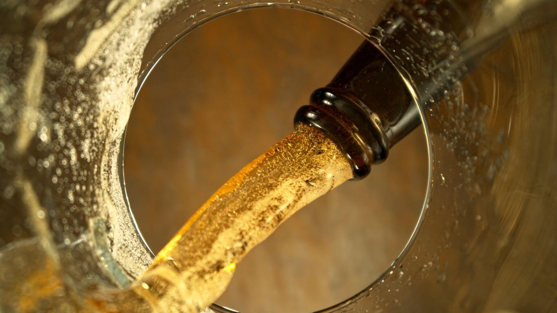 Beer from a bottle pouring in a glass