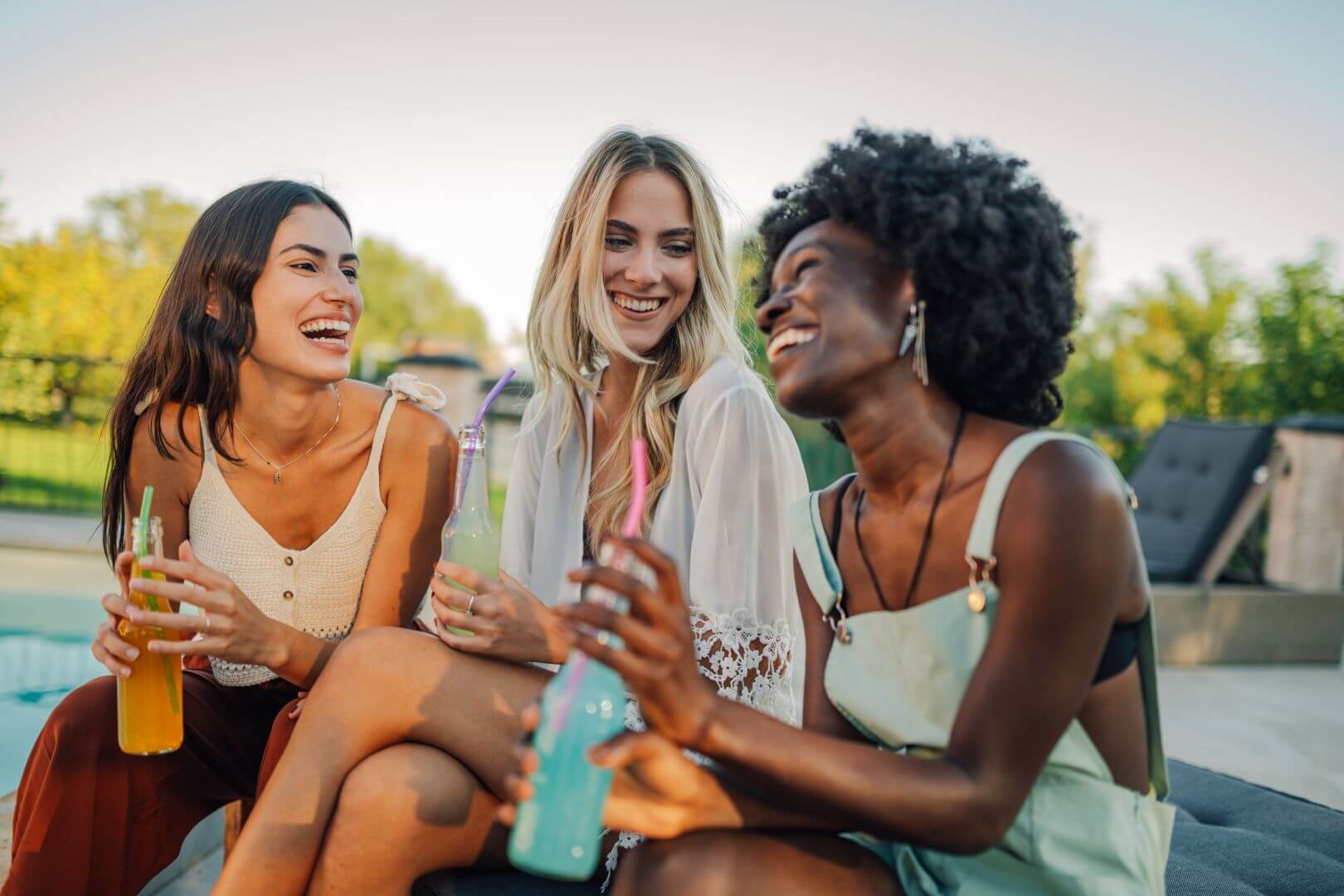 Diverse women friends drinking a variety of IFF NEO citrus-based, bottled beverages